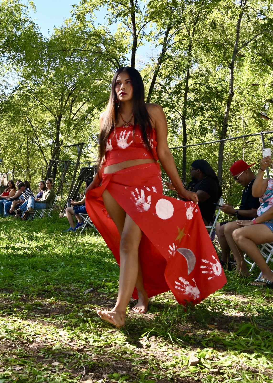 A mentee walking the runway in a red dress