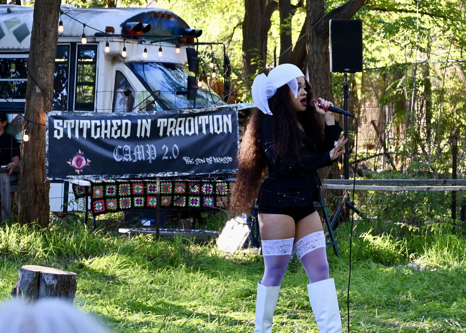 A mentee on the runway in front of the Stitched in Tradition bus